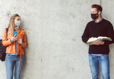 Two students standing in social distance wearing face mask