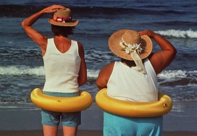 Two people on the beach looking out to sea