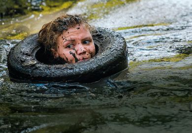 Woman in tyre in muddy river