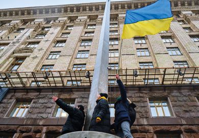 Activists hold Ukrainian flag during an action near the Kyiv City Council, demanding more money from the city budget for the Ukrainian armed forces