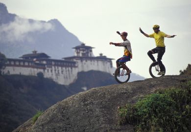 Two unicyclists on a hill