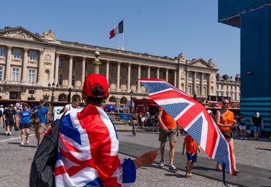 A spectator wrapped in a British Union flag shelters from the sun with an umbrella near the Paris 2024 Olympic Games Concorde stadium venue in Paris, France, 2024. To illustrate the return of the Erasmus+ programme.