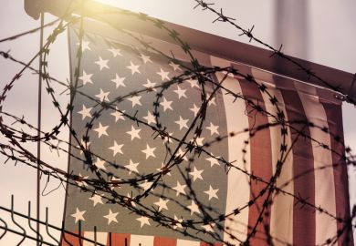 Barbed wire in front of the American flag, symbolising the crackdown on international students