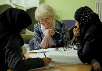 Volunteer tutor instructs asylum applicants in foreign-language class