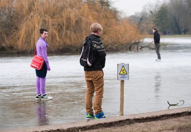 Frozen lake with sign for Danger Thin Ice with people standing on it, as an illustration of the ‘wafer-thin margins’ faced by middle-tier universities as financial challenges arise from government proposal for a overseas student levy.