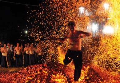 A man walking over burning coals