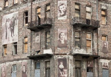 Warsaw, Poland - September 1, 2012 Holocaust memorial - a building from Warsaw ghetto with pictures of jews on the facade.