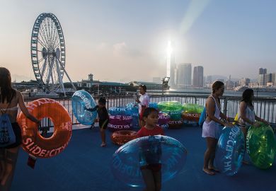 Participants wait with tubes to ride a giant waterslide set up in the Central district of Hong Kong Participants wait with tubes to ride a giant waterslide in the Central district of Hong Kong