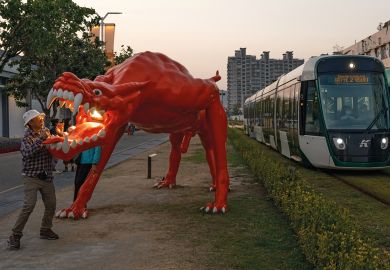 Dragon art installation outside the area of the Pier-2 Art Center in Kaohsiung, Taiwan with trams passing through to illustrate China ‘intimidating’ international academics travelling to Taiwan