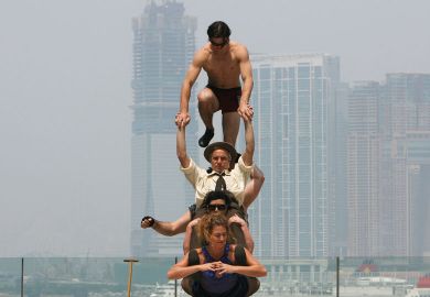 Circus Oz from Australia try to balance on each other to illustrate Overseas earnings do not balance books, Australian v-cs say