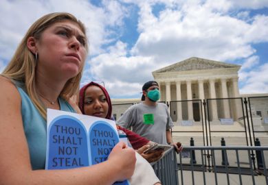 Abortion rights advocates Maddie and Rifal listen to protestors gathered outside the U.S. Supreme Court