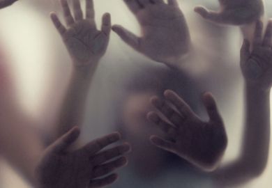 Many hands in silhouette pressed against frosted glass as a metaphor for Academic freedom can mean acknowledging trauma