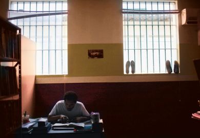 prisoner at desk with book