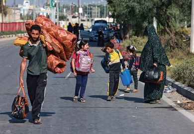 People carrying some of their belongings reach the central Gaza Strip to illustrate Gaza war drives scholars’ exodus