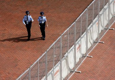 Two police officers walk alongside a steel and concrete fence erected around the Sydney Convention and Exhibition centre at Darling Harbour in Sydney to illustrate Sharing ban bill could mean jail for researchers