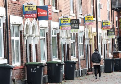 A man walks past a street of terraced houses advertising properties to illustrate Average student rents now eat up all of maintenance loan – survey