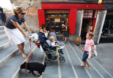 A mother carries a pram up some stairs to illustrate ‘Grant us flexibility’
