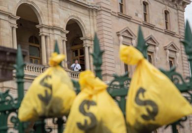 Money bags hang on a fence of the Queensland Parliament  to illustrate Record makes v-c paid