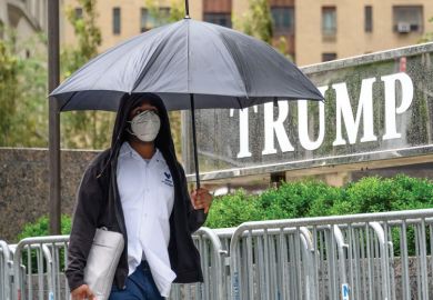 A person wears a protective face mask outside Trump International Hotel & Tower New York 