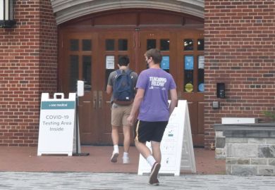 Students wearing face masks enter a makeshift COVID-19 testing area at Georgetown University 