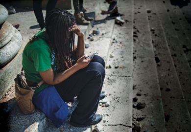 A woman looks at her phone  as she sits on steps of a University A woman looks at her phone  as she sits on steps of a University