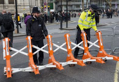 Met police officers drag barriers into place in London Met police officers drag barriers  into place to illustrate opposition in Whitehall to Home Office plan for graduate visa limits