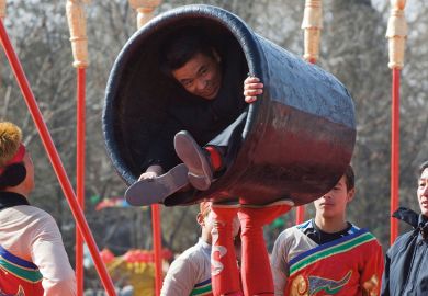 Person in a small container during a performance in China Beijing to illustrate Universities ‘in tricky position’ on Chinese student contracts