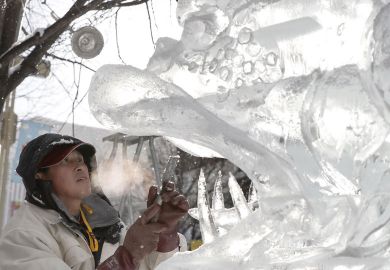  Ice Sculpture with his hands inside the mouth of a lion sculpture in Japan to illustrate Japan tries tax breaks to get companies to hire more PhD student