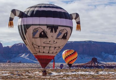 Hot air balloon flying low in Monument Valley Navajo Tribal Park in Arizonal as a metaphor for up, up and away