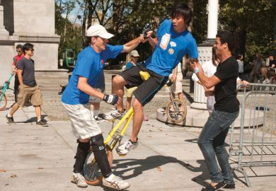Unicyclist stumbles with two people supporting him Unicyclist stumbles with two people supporting him to illustrate uncertainty on wait lists as US colleges face enrolment disruption