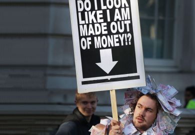 Student holds a placard dressed in bank notes to illustrate Conflict on many fronts