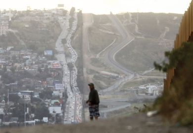 A man walks on the Mexican side of the U.S.-Mexico border barrier  A man walks on the Mexican side of the U.S.-Mexico border barrier