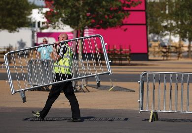  Workmen move barriers from outside the Olympic Stadium in Stratford