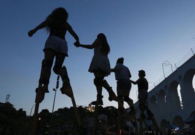 People practice walking on stilts during a stilt walking workshop as part of pre-Carnival festivities 