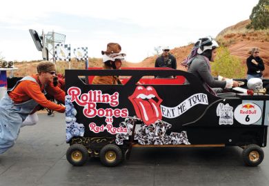Man pushing a car with a passenger and driver inside. Man pushes person in car race_as a metaphor for UK universities becoming increasingly reliant on agents for the recruitment of European Union students.