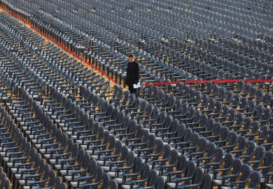 Person standing amongst empty seats as a metaphor for Concerns have been raised about the viability of some South Korean universities reported a record-high number of vacancies.