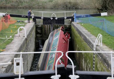 People look at a narrowboat that has capsized in a lock on the Kennet and Avon Canal  People look at a narrowboat that has capsized in a lock on the Kennet and Avon Canal