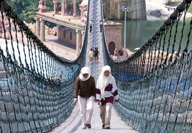 Two people walk on the world's longest pedestrian suspension bridge at Sunway Lagoon Theme Park in Kuala Lumpur to illustrate Flying high: how corporate-owned universities made a mark in Asia