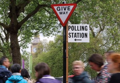 People walk near a polling station direction sign ahead of local elections, in London, Britain to illustrate Reset required