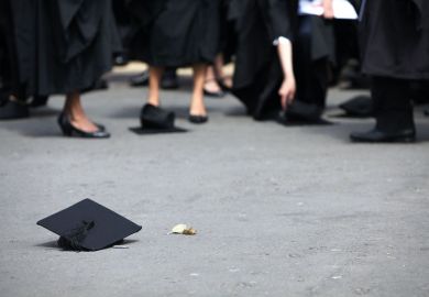 Students pick up their mortarboards from the ground to illustrate QAA’s exit leaves English sector ‘lacking expertise’ at crucial time