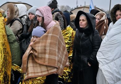 Refugees wrapped in blankets stand in line in the cold as they wait to be transferred to a train station after crossing the Ukrainian border to illustrate Five universities join forces to offer ‘wrap-around’ support to refugees