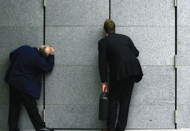 Business men stop to look through the gap in a construction block Business men stop to look through the gap in a construction block to illustrate Research council head veto ‘will make vacancies harder to fill’