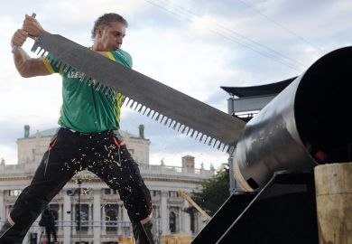 Person competes in a wood chopping competition to illustrate enmark cuts undergraduate numbers but aims for overseas growth
