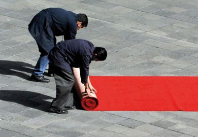 wo workers of the Mexican National Palace, roll a red carpet to illustrate Tec de Monterrey splashes out $100 million on top Western scholars