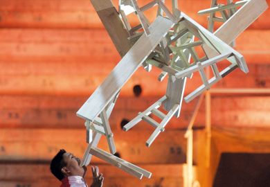 Chinese performer Guozhi Guo balances a stack of wooden trestle tables on his chin Chinese performer Guozhi Guo balances a stack of wooden trestle tables on his chin Weekend courses seek to give Chinese graduates employment edge