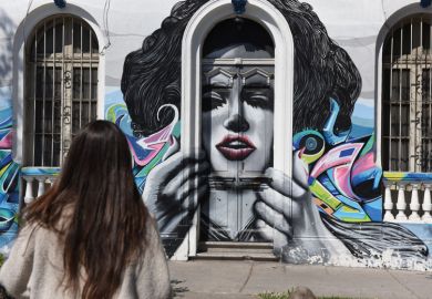 A woman walks past street art in Bellavista neighbourhood.