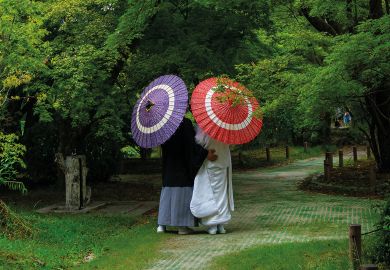 Japanese couple with umbrellas in the botanic garden, Kansai region, Kyoto, Japan to illustrate Newly merged Japan university ‘model’ for sector, says president