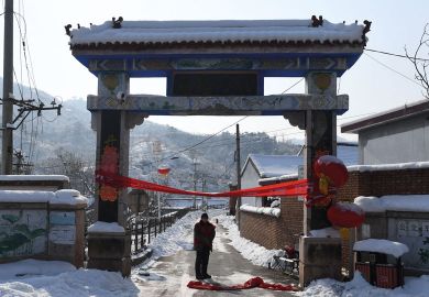 Residents stand at the entrance to Beicibeiyu village, blocked off to illustrate Experts doubtful as China launches new open access push