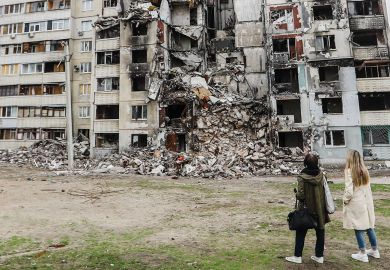 People looking at damaged residential buildings in Ukraine to illustrate I’ve finally quit the UCU after its hard-left motion on Ukraine war