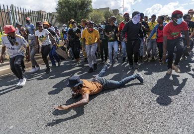 Student on the ground at a protest over university fees in Johannesburg, South Africa  Student on the ground at a protest over university fees in Johannesburg, South Africa to illustrate Are South African  universities falling?